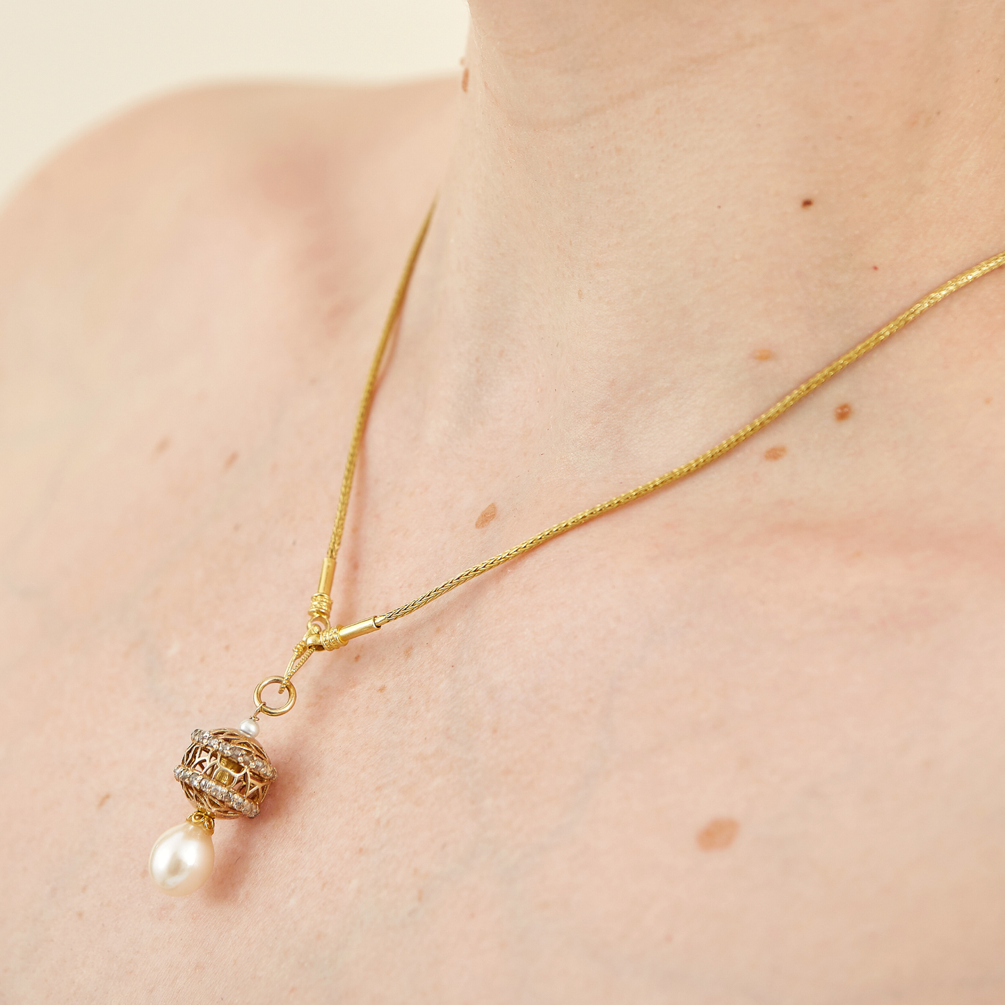 18 Kt Yellow Gold Necklace with two rims of champagne-like diamonds and pearl drop at the bottom