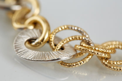 An 18K yellow and white gold bracelet featuring a bold mix of polished, hammered, and twisted textures. Artful and architectural with timeless appeal.

