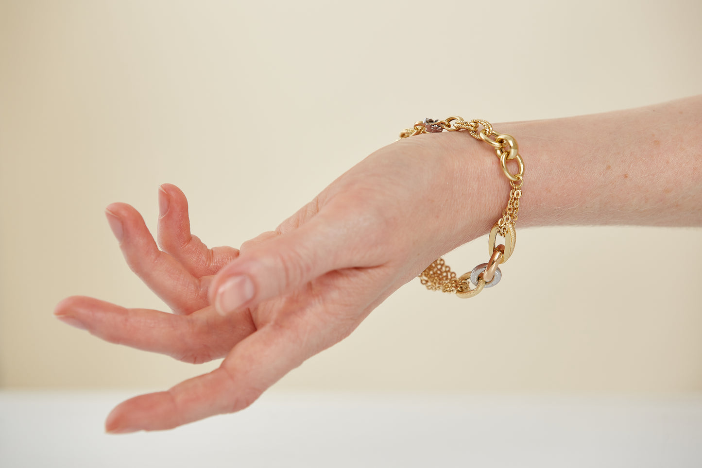 Bold yet graceful, this 18K gold bracelet features layered chains and textured links in yellow, rose, and white gold. A standout mixed-metal design for everyday elegance.
