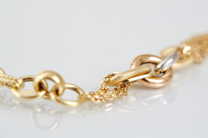 Bold yet graceful, this 18K gold bracelet features layered chains and textured links in yellow, rose, and white gold. A standout mixed-metal design for everyday elegance.
