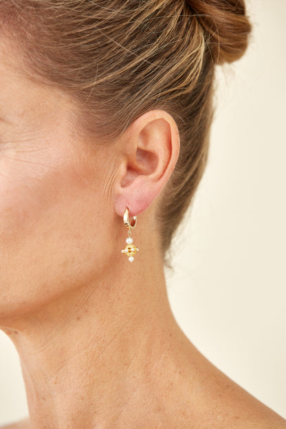 Classic drop earrings featuring delicate pearls set in ornate 18K yellow gold. A timeless design echoing vintage South Asian craftsmanship.
