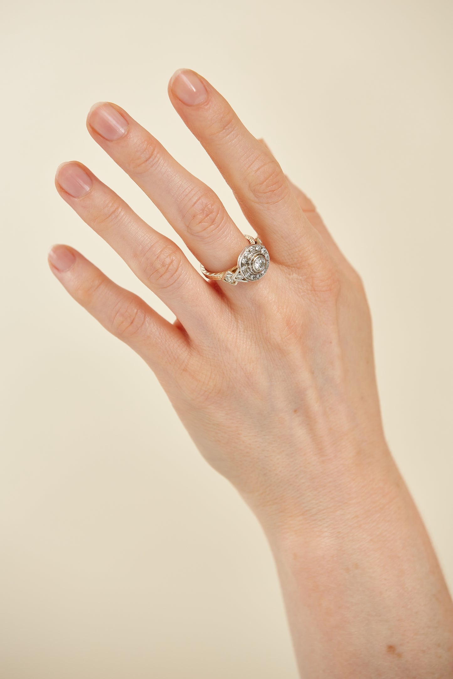 Art Deco–inspired 18K gold ring with a bezel-set centre diamond and surrounding halo. A bold, symmetrical masterpiece with vintage glamour.
