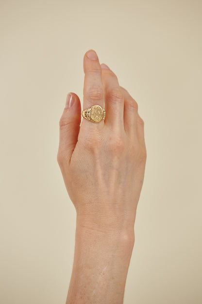 Classic 18K gold signet ring with intricate engraving. A timeless heirloom piece, rich in character and personal style.
