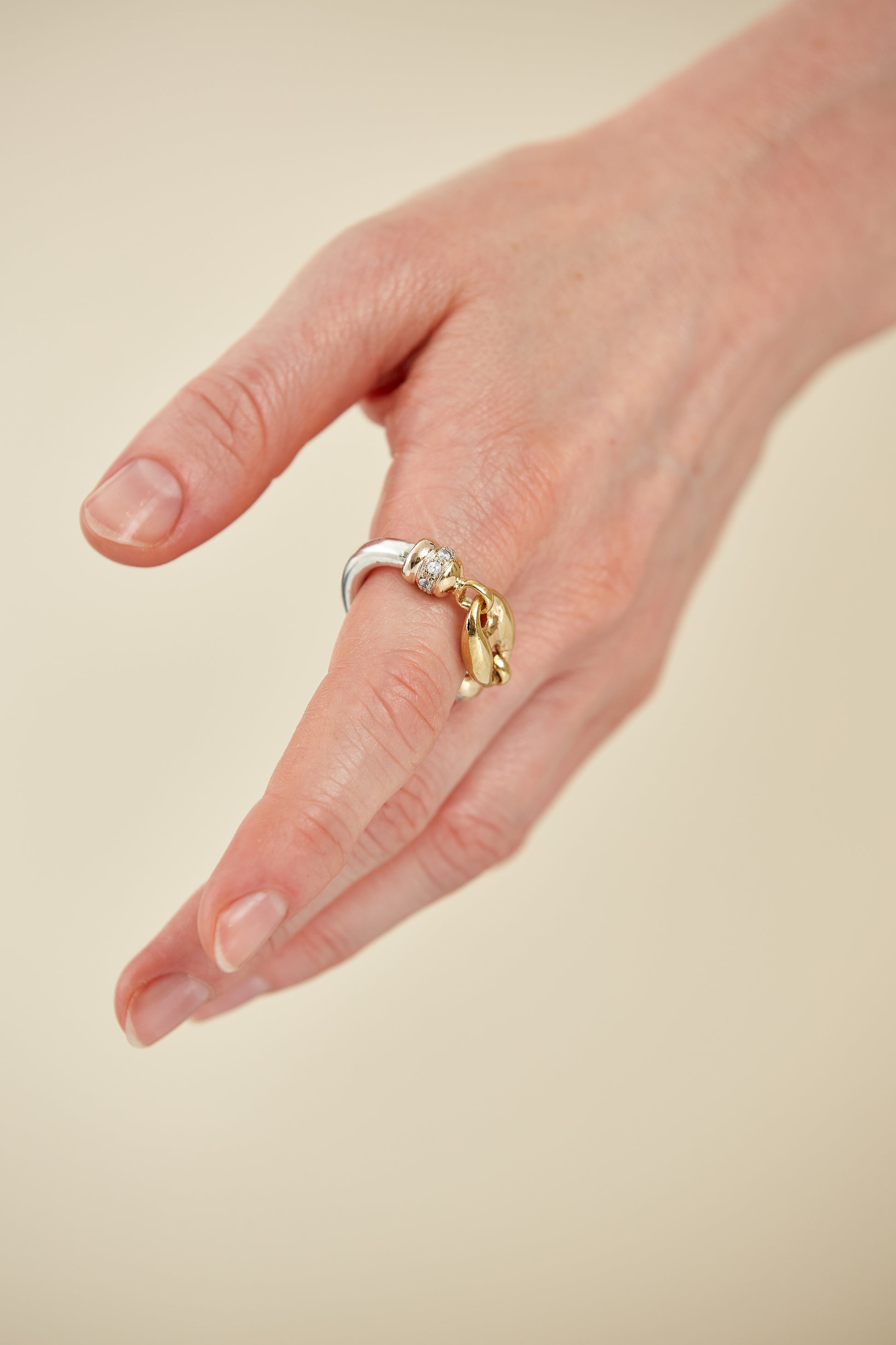 Bold sculptural ring in polished mixed metals with oversized link design. A modern, industrial-chic statement piece with high shine and edge.
